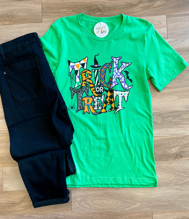 green tee with Trick or Treat in fun lettering and orange, black, purple designs