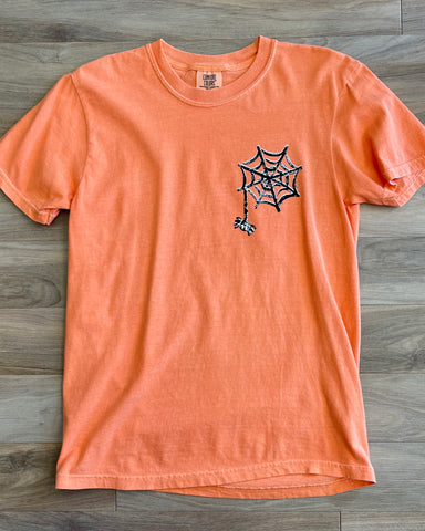 orange comfort colors tee, spider web on front left chest area