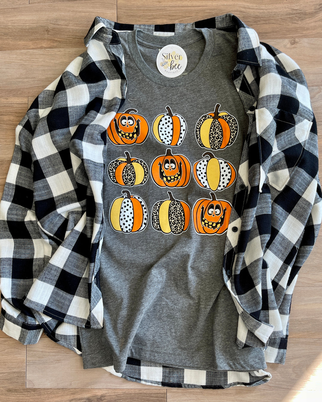 soft grey tee with 9 patterned pumpkins with silly faces, paired with black and white flannel (items sold separately)